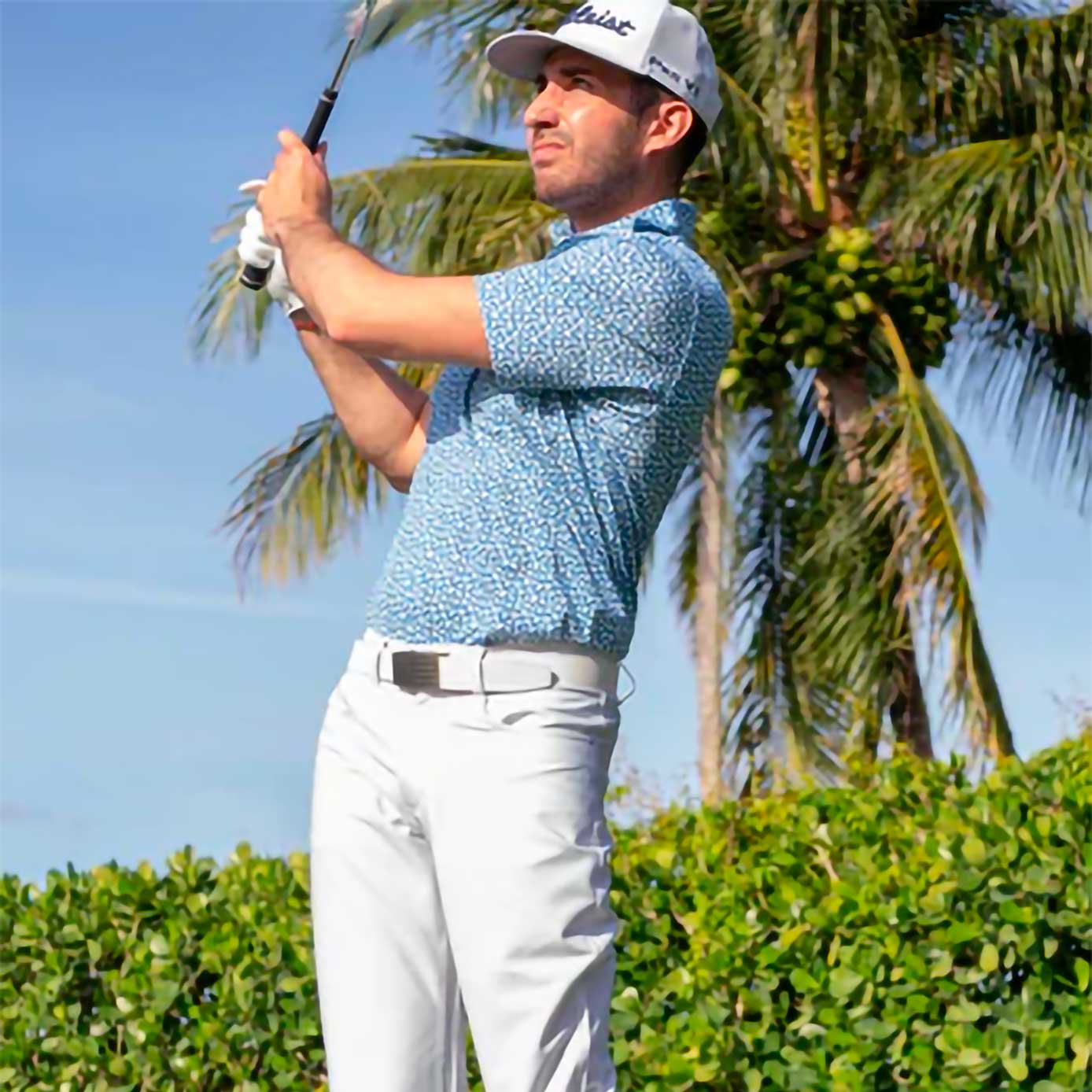 Man wearing white pants with white belt playing golf